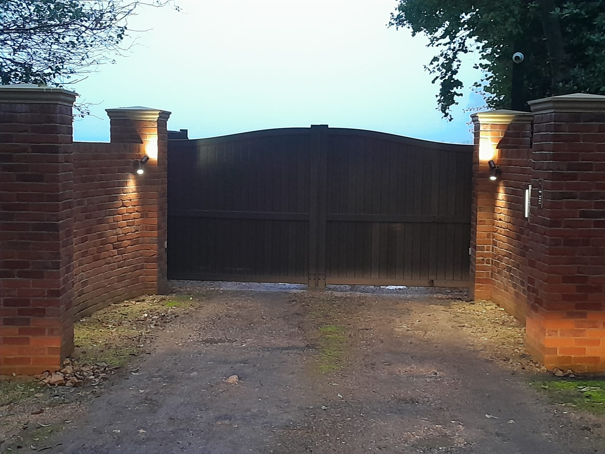 Illuminated brick gate pillars at night