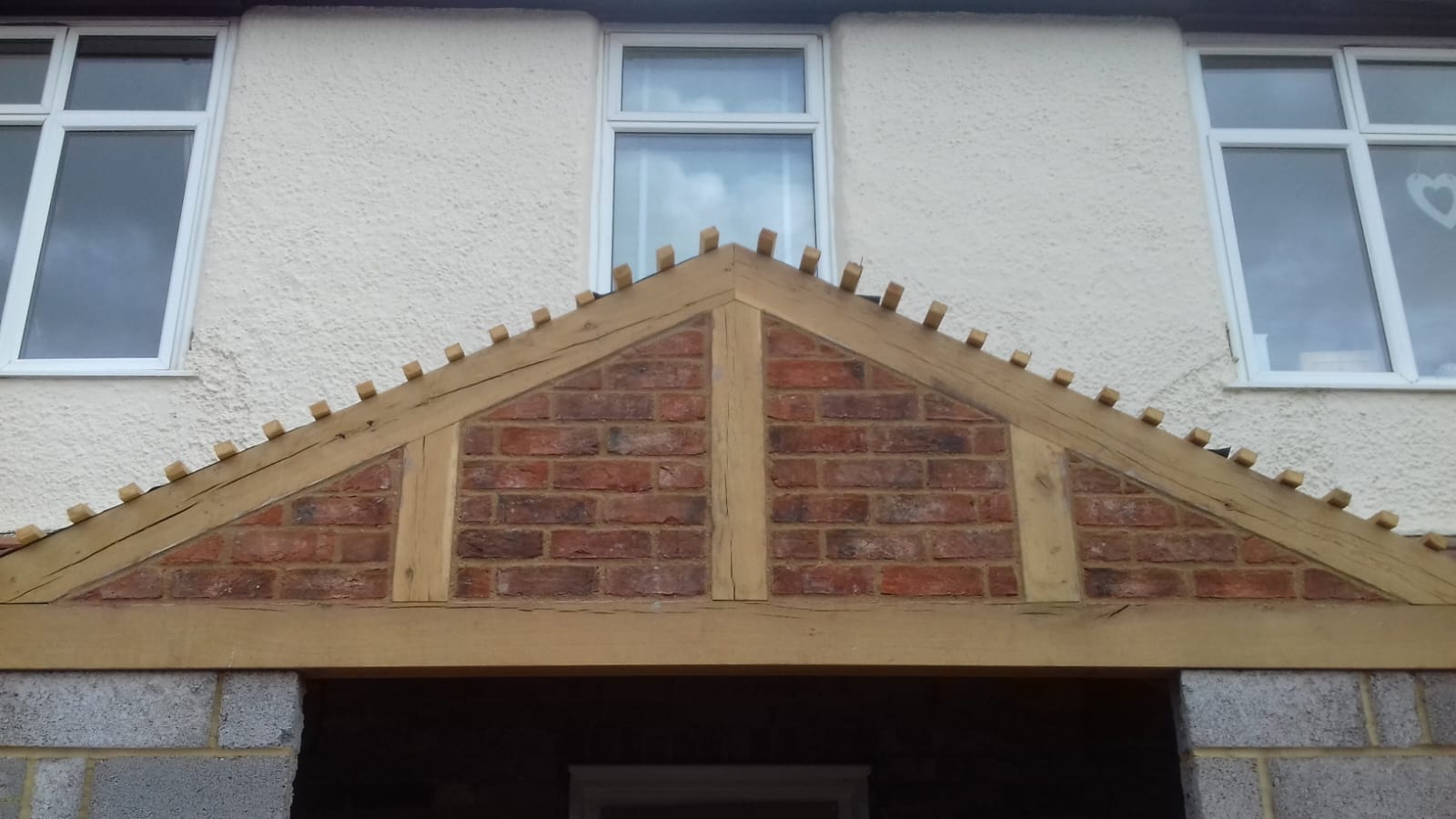 Brick gable set within oak timber frame porch